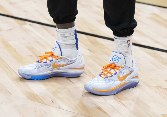 View of white, orange, and blue Nike shoes.